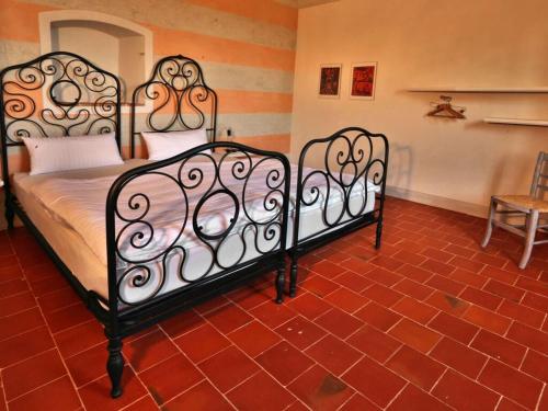 2 Metallbetten in einem Zimmer mit rotem Fliesenboden in der Unterkunft Holiday home Casa Nanda in Mombaruzzo