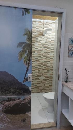 a bathroom with a toilet and a stone wall at Brumar Inn in Angra dos Reis