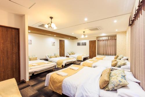 a hotel room with four beds in a room at #10 -名古屋サンフラワーコンドミニアム- 大曽根駅 in Yadachō