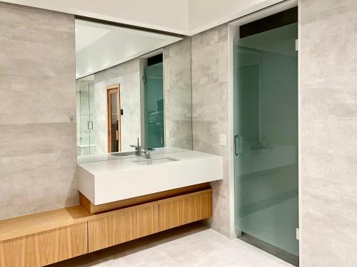 bagno con lavandino bianco e specchio di Cozy Suite in Vancouver West a Vancouver