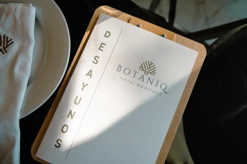 a sign for a restaurant on a table with a plate at BOTANIQ HOTEL BOUTIQUE in Valle de Bravo