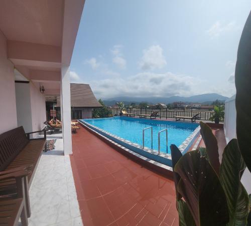 a large swimming pool with benches in a building at Vangvieng Sisavang Mountain View Hotel in Vang Vieng