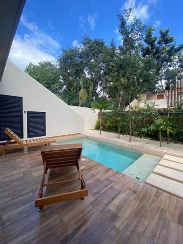 a swimming pool with a chair next to a house at ¡New Villa 4BR with priv jacuzzi! in Tulum