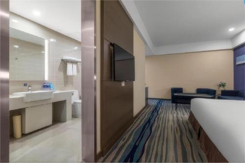 瀋陽市にあるホリデイ イン エクスプレス 瀋陽北駅の洗面台とバスルームが備わるホテルルームです。
