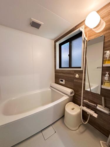 a bathroom with a bath tub and a toilet at X101Near Nagoya Station detached hous 12 people in Nagoya