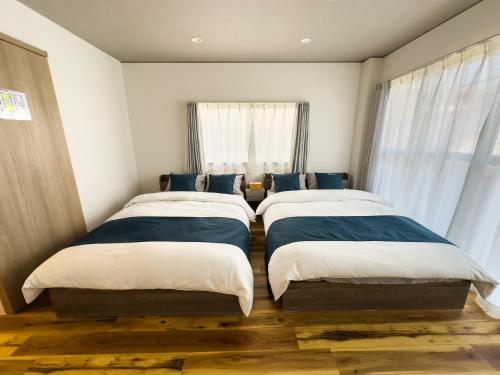 a bedroom with two beds and a window at X101Near Nagoya Station detached hous 12 people in Nagoya