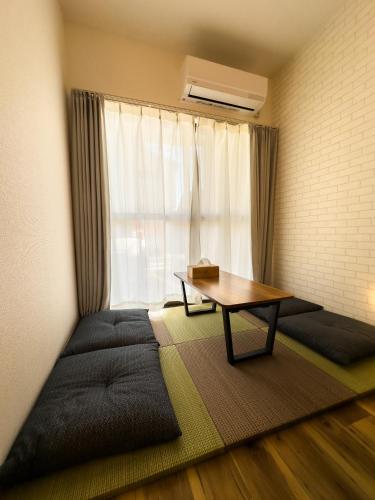 a room with a bed and a table and a window at X101Near Nagoya Station detached hous 12 people in Nagoya