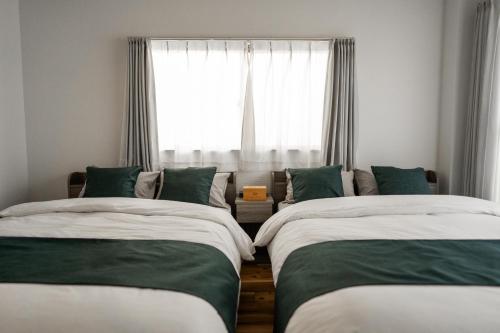 two beds in a room with a window at X101Near Nagoya Station detached hous 12 people in Nagoya