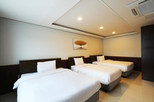 a hotel room with two beds with white sheets at Intercity Seoul Hotel in Seoul