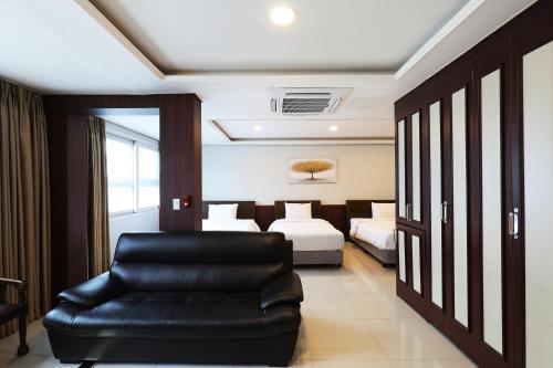 a living room with a black leather chair and a bedroom at Intercity Seoul Hotel in Seoul