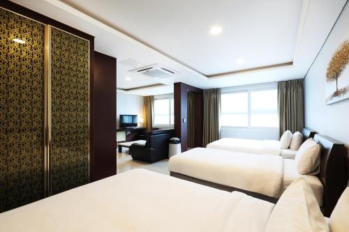 a hotel room with two beds and a desk at Intercity Seoul Hotel in Seoul