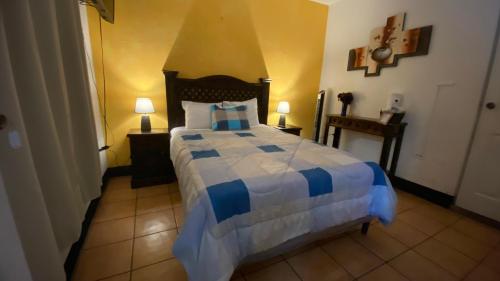 a bedroom with a blue and white bed with two lamps at Hotel y Restaurante San Fernando. in Jocotenango