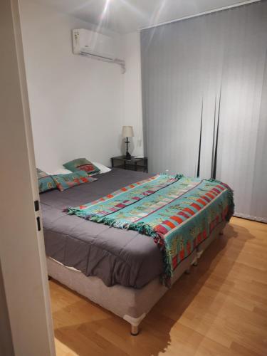 une chambre avec un lit avec une couette dessus dans l'établissement caseros apart, à Salta