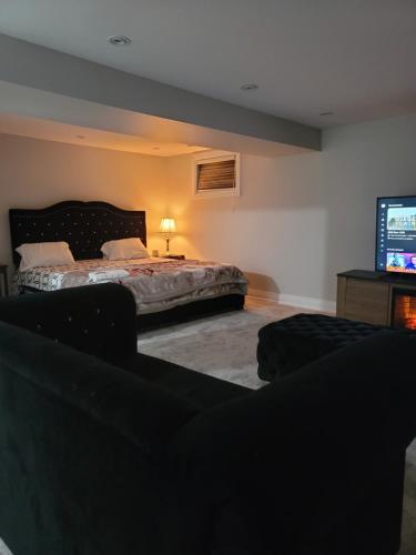 Langston Beautiful Home في برامبتون: غرفة نوم بسرير وتلفزيون بشاشة مسطحة