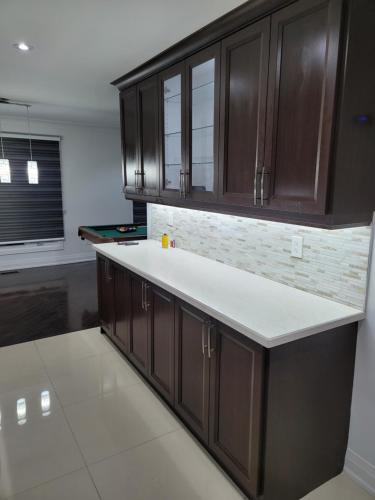 a kitchen with brown cabinets and a white counter top at Langston Beautiful Home in Brampton