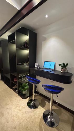 a office with a desk with a laptop and stools at Mango Hotel - Ha Noi Railway station in Hanoi