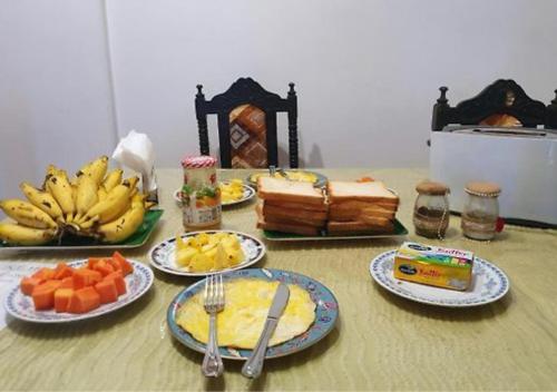 a table with plates of food and fruit on it at Feel Like Home Anuradhapura in Anuradhapura
