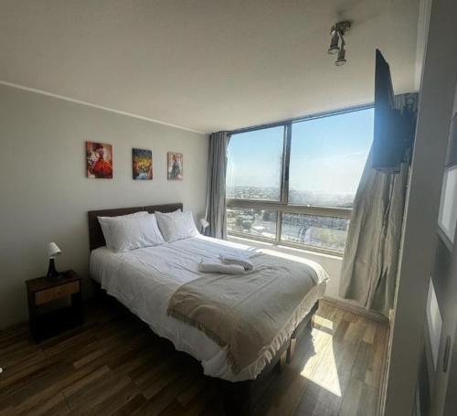 a bedroom with a bed and a large window at Best Apartment Rental Estación Central in Santiago