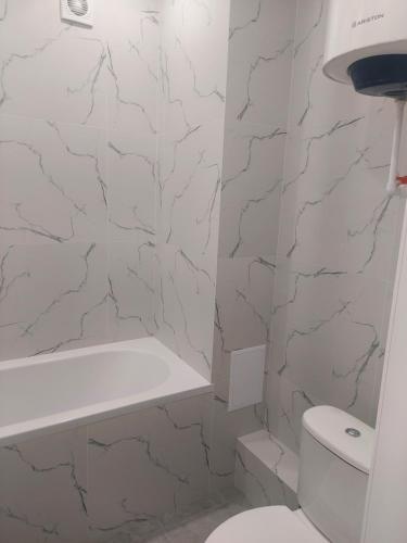 biała łazienka z toaletą i wanną w obiekcie Квартира посуточно w mieście Kokczetaw