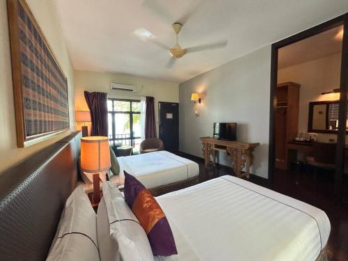 a hotel room with two beds and a couch at Tunamaya Beach & Spa Resort Tioman Island in Tioman Island