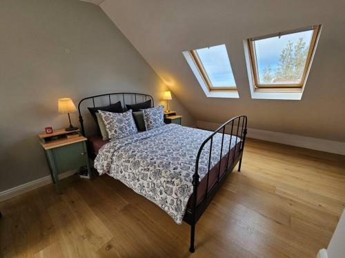 ein Schlafzimmer mit einem Bett und zwei Fenstern in der Unterkunft Sunny 2BR Apartment in Downtown Reykjavik in Reykjavík