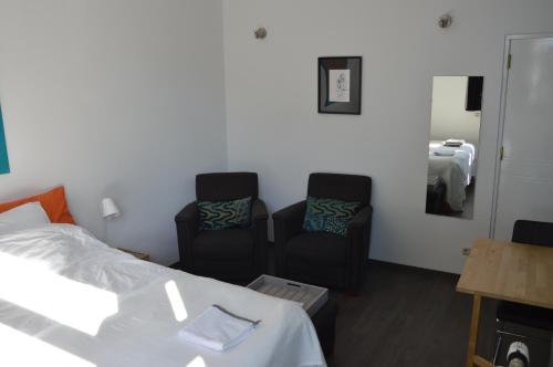 a hotel room with two chairs and a bed at Het blauwe huis in Reuver