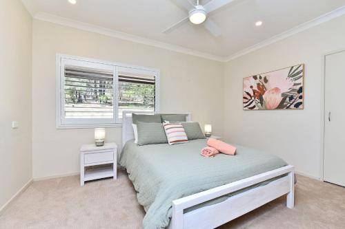 a white bedroom with a bed and a window at Kookaburra Range in Greta