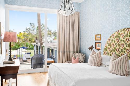 1 dormitorio con 1 cama y ventana con balcón en Halcyon House en Cabarita Beach