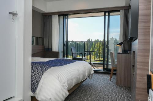 Cette chambre d'hôtel comprend un lit et un balcon. dans l'établissement Airport Hotel Kumamoto, à Ozu