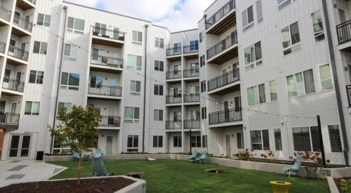 a large white apartment building with a yard at Cozysuites l Gorgeous 1BR in Downtown Cincinnati in Cincinnati