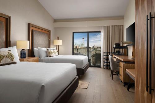 a hotel room with two beds and a desk at Plaza San Antonio Hotel & Spa, Autograph Collection in San Antonio
