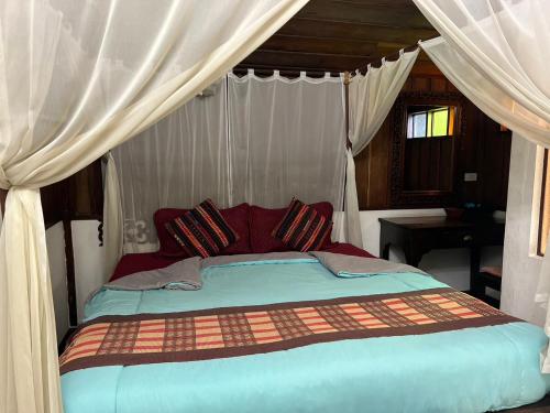 a bedroom with a bed with a canopy at The Royal Shilton Resort in Chiang Mai