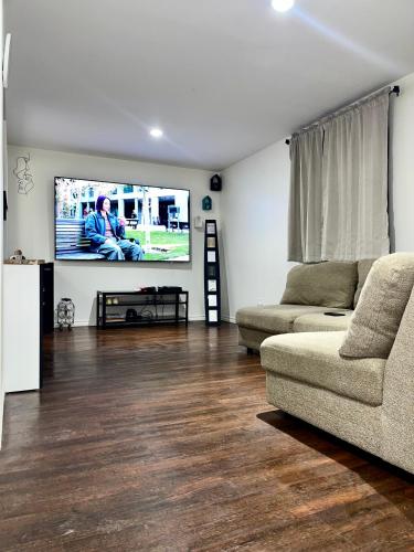 een woonkamer met een bank en een flatscreen-tv bij Separate Suite in Calgary