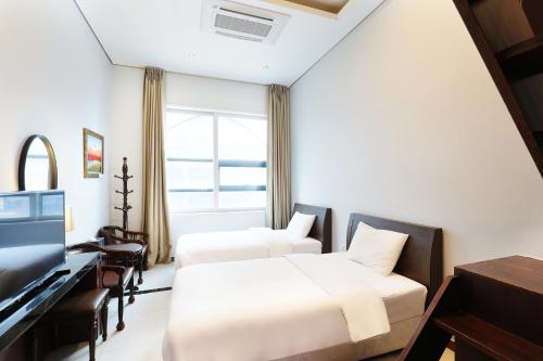 a hotel room with two beds and a television at Intercity Seoul Hotel in Seoul