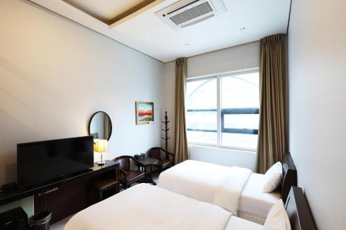 Habitación de hotel con cama y TV en Intercity Seoul Hotel, en Seúl