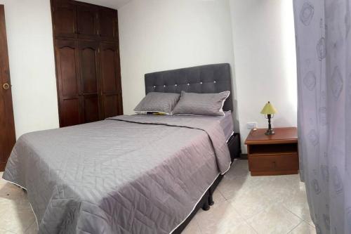 ein Schlafzimmer mit einem Bett und einem Tisch mit einem Nachttisch in der Unterkunft Apartamento en Bello Medellín in Bello