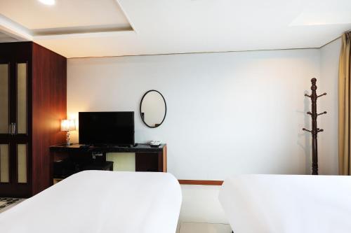 a bedroom with a bed and a mirror and a tv at Intercity Seoul Hotel in Seoul