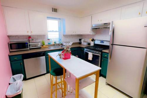 une cuisine avec des armoires vertes et un réfrigérateur blanc dans l'établissement Cozy 3BR Stay, EZ Access to NYC, à Newark