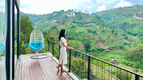 a woman standing on a balcony looking out at the mountains at Thalassaville Dago Bandung in Bengkok
