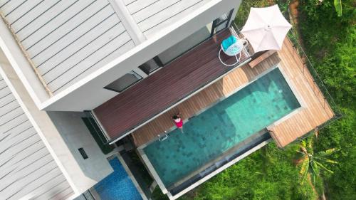 an overhead view of a swimming pool with a woman sitting in a chair at Thalassaville Dago Bandung in Bengkok