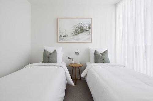ニューカッスルにあるAmaya - 2 bed optionの白い壁と窓のある部屋にベッドが2つある