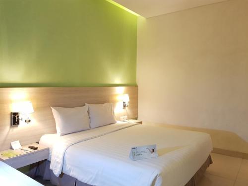 Postel nebo postele na pokoji v ubytování Whiz Prime Hotel Kelapa Gading
