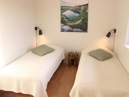 2 camas en una habitación con paredes blancas en 4 person holiday home in R nne, en Rønne