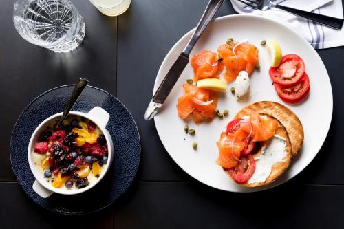 a table with a plate of food and a bowl of soup at Kimpton Hotel Palomar Los Angeles Beverly Hills by IHG in Los Angeles