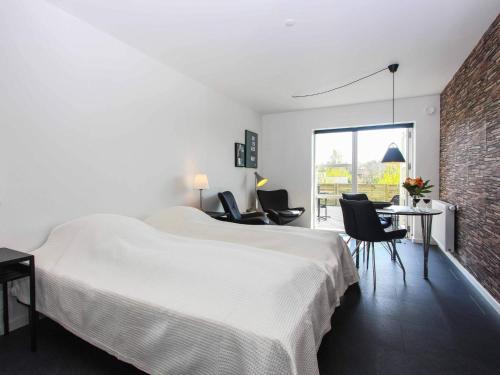 a bedroom with a large white bed and chairs at 2 person holiday home in Nex in Neksø