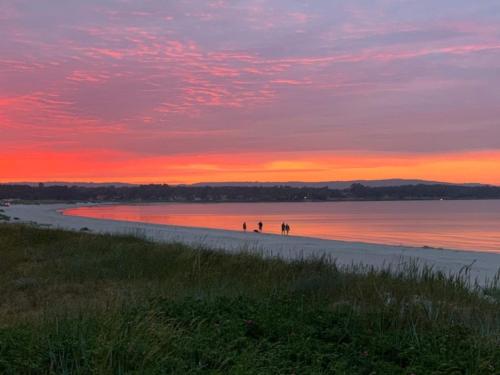 eine Gruppe von Menschen, die bei Sonnenuntergang am Strand spazieren gehen in der Unterkunft 2 person holiday home in Nex in Neksø
