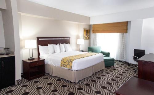 um quarto de hotel com uma cama e uma cadeira em Baymont by Wyndham Delavan Near Lake Geneva em Delavan