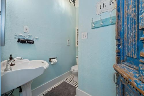 Baño azul con lavabo y aseo en Rooster House Countryside Pecan Farm 14ac SanMarcos, en Maxwell