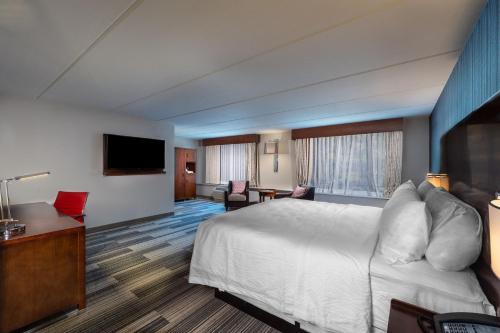 a hotel room with a bed and a flat screen tv at Four Points by Sheraton Atlanta Airport West in Atlanta