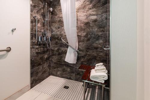 a bathroom with a shower with a table and towels at Four Points by Sheraton Atlanta Airport West in Atlanta